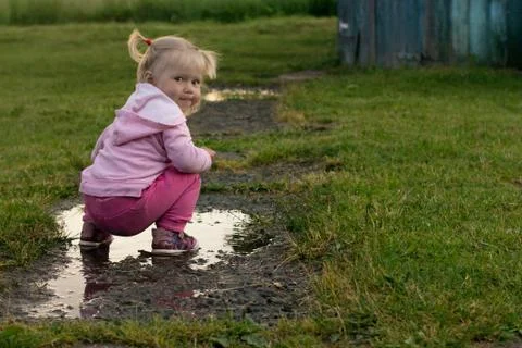 Portrait of a Child in a Dirty Puddle Stock Photos