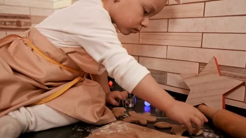 Portrait of a child in a kitchen apron baking gingerbread cookies with parents, Stock Footage 288450776