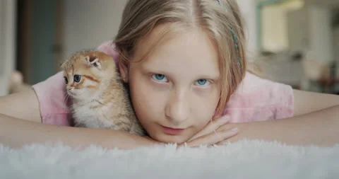 Portrait of a child with a kitten looking at the camera Stock Footage 233096885