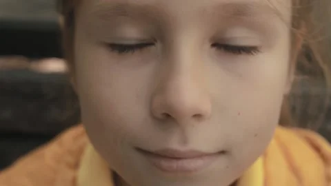 Portrait of a child looking at the camera. Cute baby is sitting on a park bench. Stock Footage 163315619