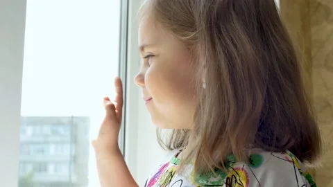 Portrait of a child looking out through the window Stock Footage 132486935