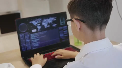 Portrait of child prodigy boy is programming the code behind a laptop at home Vidéo 133609980