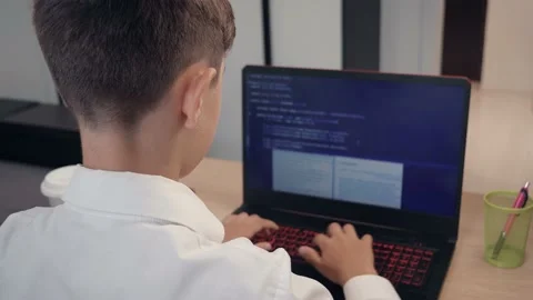 Portrait of child prodigy boy is programming the code behind a laptop at home Vidéo 133628575