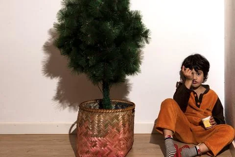 Portrait of a child sit wait to set up the Christmas tree Stock Photos