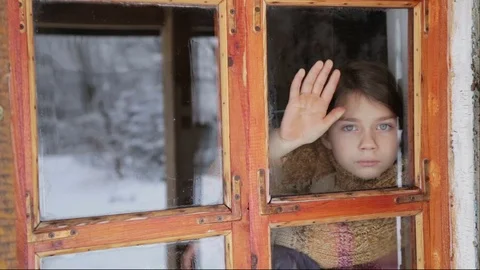 Portrait of child in the window. Sad boy looks out the window. Vidéo 71671469