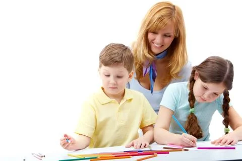 Portrait of children drawing pictures and teacher standing near Stock Photos