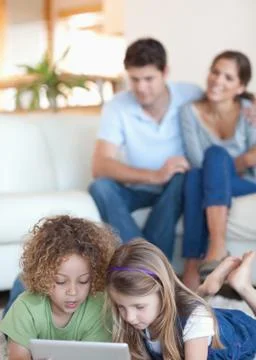 Portrait of children using a tablet computer while their parents are watching 스톡 사진
