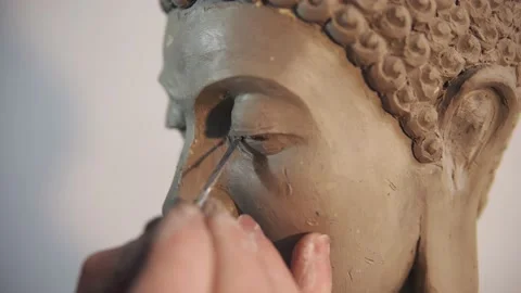 Portrait of clay Buddha's statue face, artist works with details using spatula 스톡 동영상 149138460