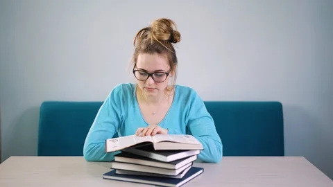 Portrait of clever student with open book reading it in college library 動画素材 88902166