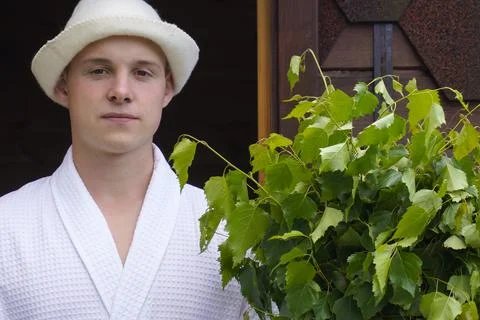 Portrait close-up. nice positive guy poses with a bath broom, laughs, leads a Foto stock