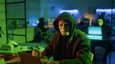 Portrait of Computer Criminal Wearing Hacker Mask with Serious Look in Office Stock Footage 299255824