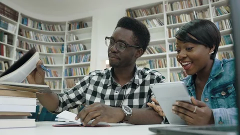 Portrait of concentrated african students using tablet in library. Stock Footage 101755112