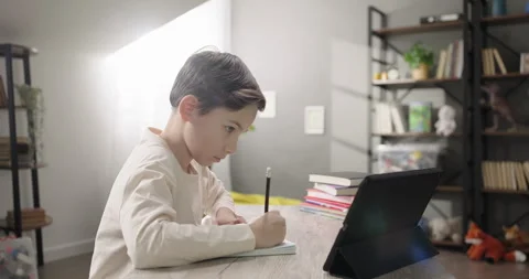Portrait of a concentrated boy e-learning online using app or website on digital Stock Footage 269053185