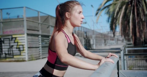 Portrait of concentrated female doing workout push-ups leaning at fence sport Stock Footage 117692871