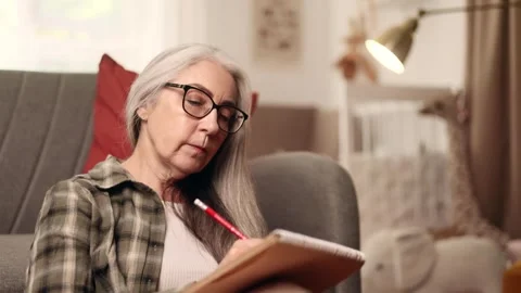 Portrait of concentrated gray haired senior woman sitting on the floor holding Stock Footage 252127177