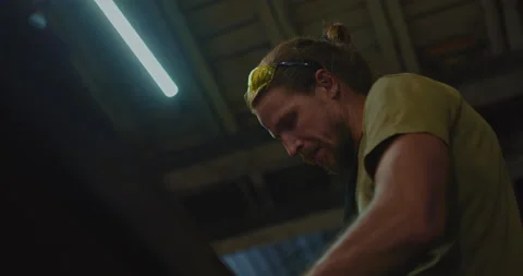 Portrait of concentrated master in workshop, man is working, sharpen knife, 4K Stock Footage 205159867