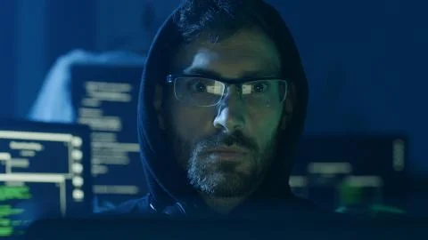 Portrait of concentrated programmer looking at computer interface sitting at Stock Photos