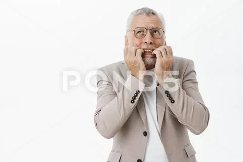 Portrait of concerned panicking and worried senior bearded man in glasses and Stock Photos