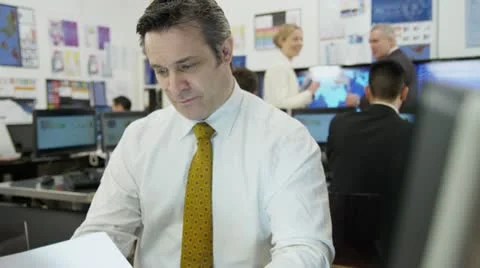 Portrait of a confident and mature stock market trader at work in a busy office Stock Footage