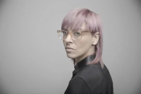 Portrait confident beautiful non-binary gender person with pink hair and eyeglas Stock Photos