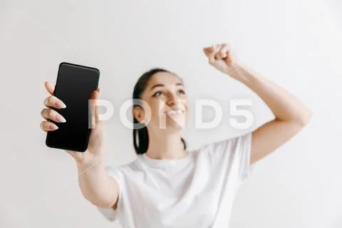 Portrait of a confident casual girl showing blank screen of mobile phone Stock Photos