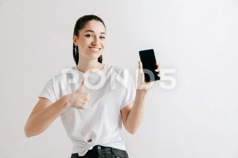 Portrait of a confident casual girl showing blank screen of mobile phone Stock Photos