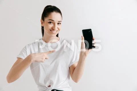 Portrait of a confident casual girl showing blank screen of mobile phone Stock Photos