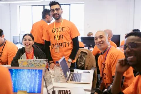 Portrait confident hackers coding for charity at hackathon Foto stock