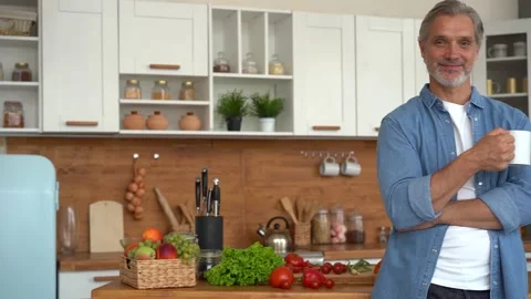 Portrait of confident man standing in kitchen, smiling, looking at camera. Stock Footage 139743458