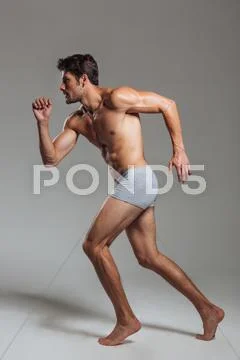 Portrait of a confident naked athletic man in underwear posing Stock Photos