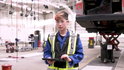 Portrait confident non binary mechanic with digital tablet in garage Video stock 221036112