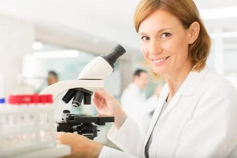 Portrait of confident scientist using microscope in laboratory Foto stock