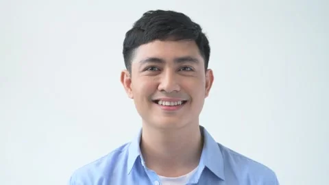 Portrait of confident smiling young man laughing against blue light backgroun Stock Footage 156174804