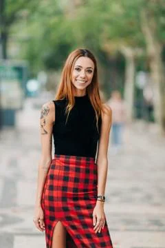 Portrait confident, stylish young woman in checked skirt Stock Photos