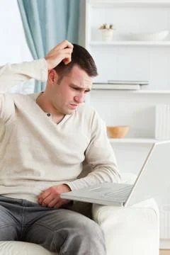 Portrait of a confused man using a notebook Stock Photos