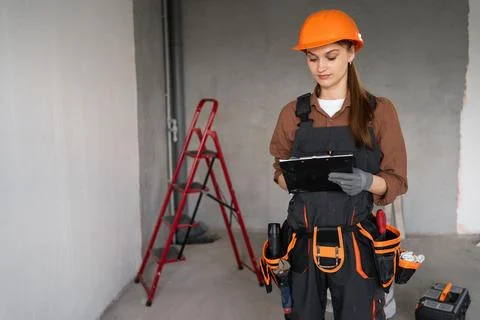 Portrait of construction worker or builder with clipboard in room new buildin Stock Photos