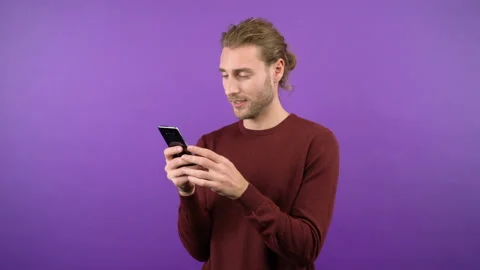 Portrait of a contented surprised long-haired man browsing the browser. A man on Stock Footage 145412822