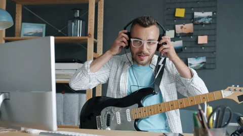 Portrait of cool musician using computer then putting on headphones and playing Stock Footage 158086336