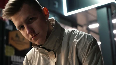 Portrait of cool serious guy looking at camera near the mall at night 動画素材 108123602