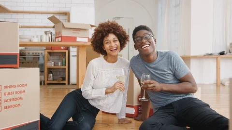 Portrait Of Couple Celebrating Moving Into New Home With Glass Of Wine Stock Footage