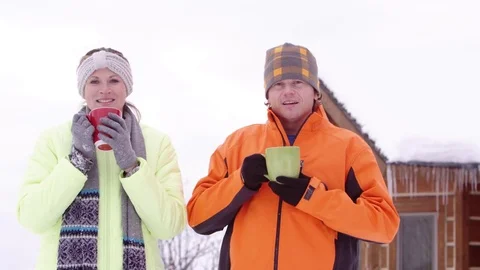 Portrait of couple drinking hot drink in the cold winter Stock Footage 80128056