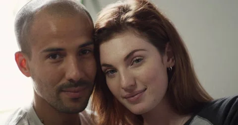 Portrait of couple sitting close to each other in living room Stock Footage 63374080