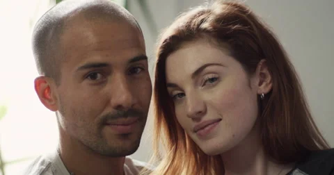 Portrait of couple sitting close to each other in living room Vídeo Stock 63374095