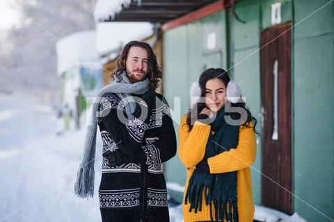 A portrait of couple standing outdoors in winter, looking at camera. Stock Photos