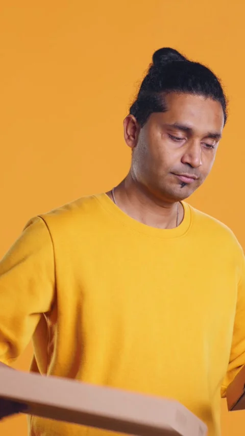 Portrait of courier carrying stack of pizza boxes, studio background Video stock 274316391