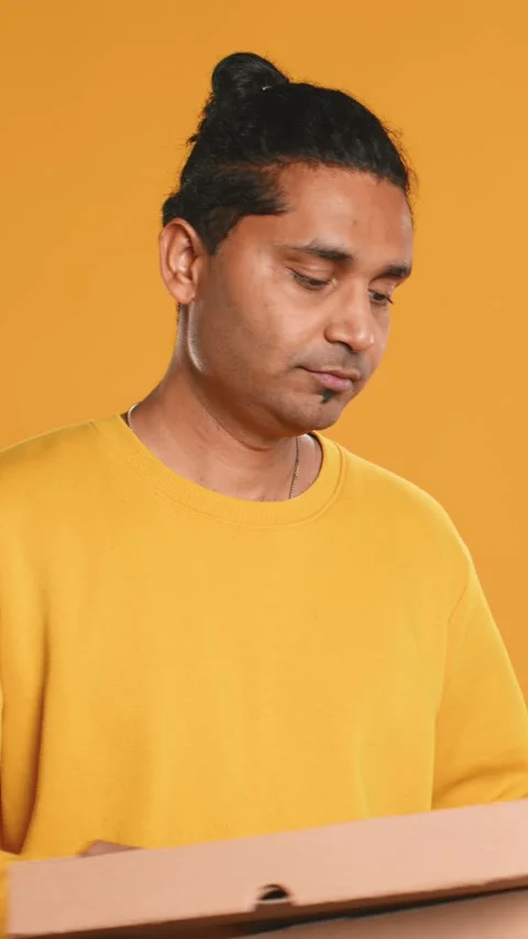 Portrait of courier carrying stack of pizza boxes, studio background Video stock 274316650