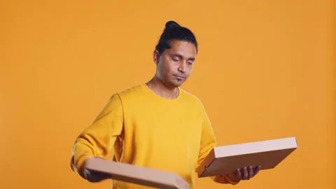 Portrait of courier carrying stack of pizza boxes, studio background Video stock 274332443