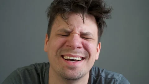 Portrait of crazy laughter of a drunk or drugged young man looking at camera. Video stock 153017851