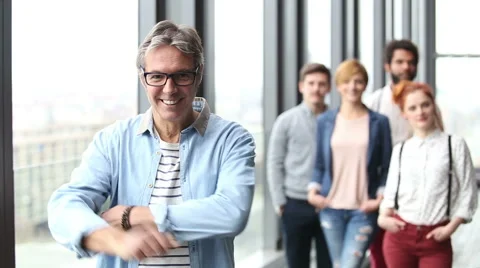 Portrait of creative director smiling, colleagues in background Stock Footage 59543152