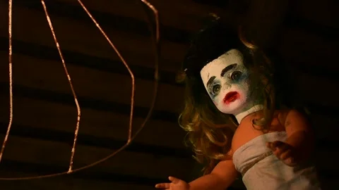 Portrait of a creepy doll in front of a rusty lampshade Stock Footage 139694347